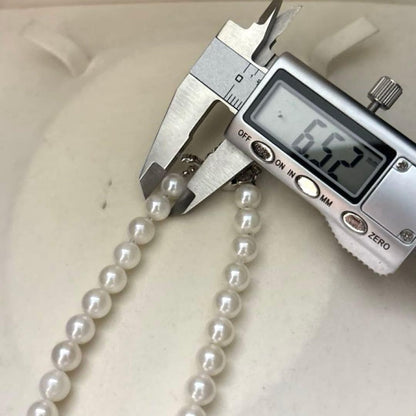 Akoya pearl necklace with 7mm round white pearls and silver markings, 43cm length, strong luster