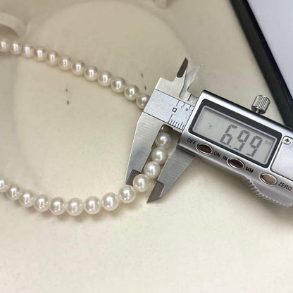 Akoya pearl necklace with 7mm round white pearls and silver markings, 43cm length, strong luster