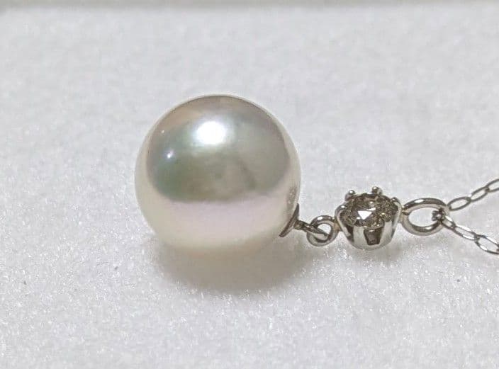 Akoya pearl and diamond pendant necklace featuring 8.3mm round white-green pearl with platinum chain