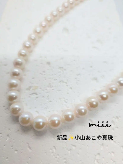 Close-up of an Akoya pearl necklace with 6.5-7mm pearls and a sterling silver clasp on a white background