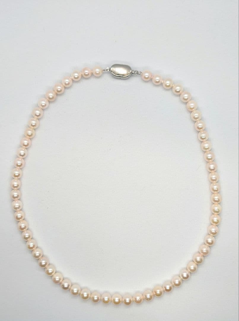 Close-up of an Akoya pearl necklace with 6.5-7mm pearls and a sterling silver clasp on a white background