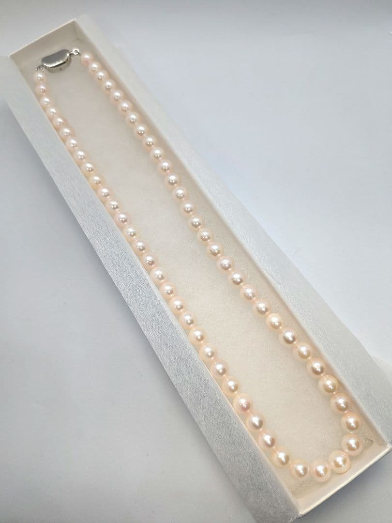 Close-up of an Akoya pearl necklace with 6.5-7mm pearls and a sterling silver clasp on a white background