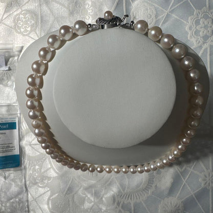 Akoya pearl necklace with 8.0-8.5mm white pearls and silver stamped clasp with certification tag