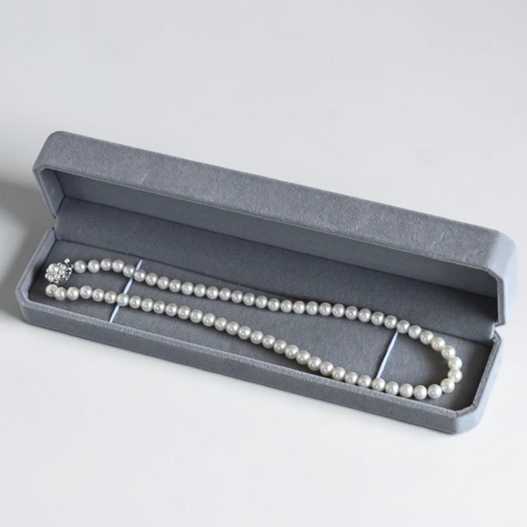 Takaski pearl necklace featuring 6.5mm Akoya round pearls and silver clasp on a white background
