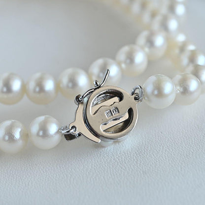 Takaski pearl necklace featuring 6.5mm Akoya round pearls and silver clasp on a white background