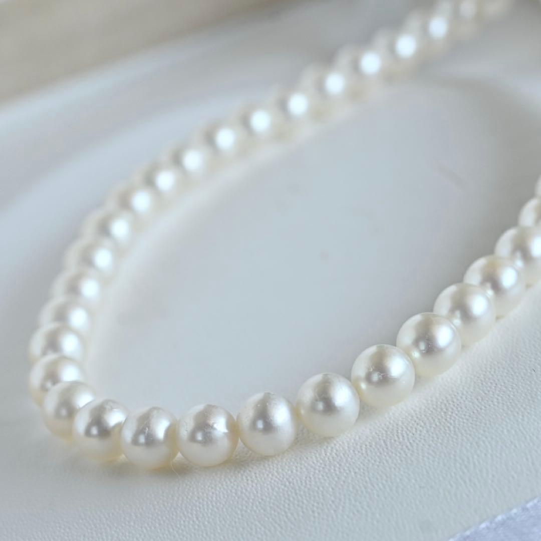 Takaski pearl necklace featuring 6.5mm Akoya round pearls and silver clasp on a white background