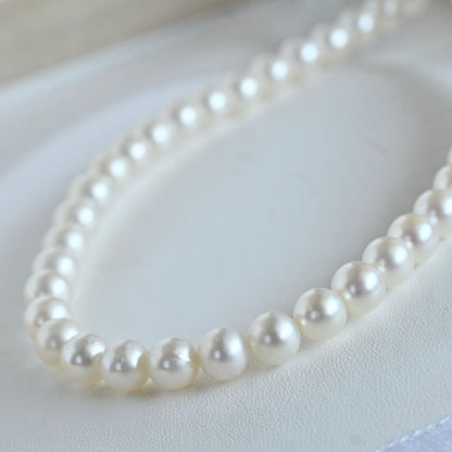 Takaski pearl necklace featuring 6.5mm Akoya round pearls and silver clasp on a white background