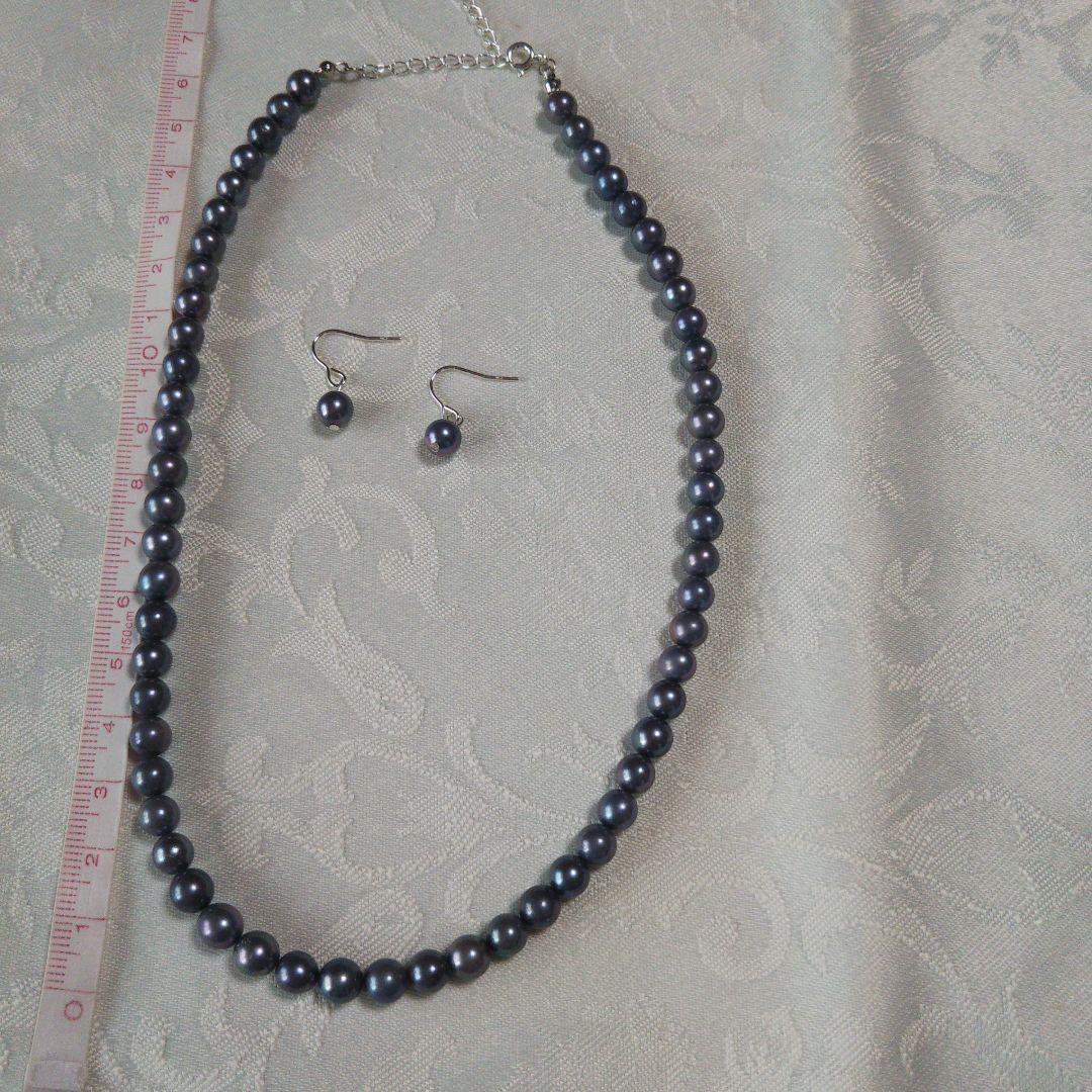 Akoya pearl necklace and matching earrings with silver clasp and findings on white background