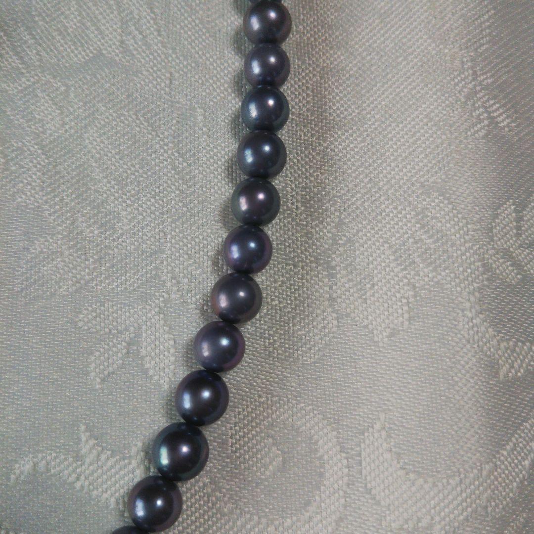 Akoya pearl necklace and matching earrings with silver clasp and findings on white background