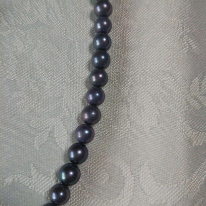Akoya pearl necklace and matching earrings with silver clasp and findings on white background