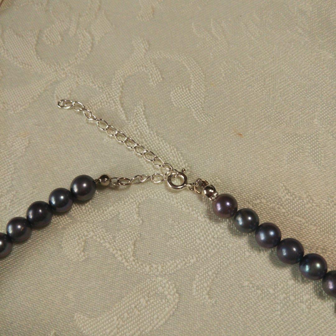 Akoya pearl necklace and matching earrings with silver clasp and findings on white background