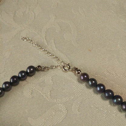 Akoya pearl necklace and matching earrings with silver clasp and findings on white background