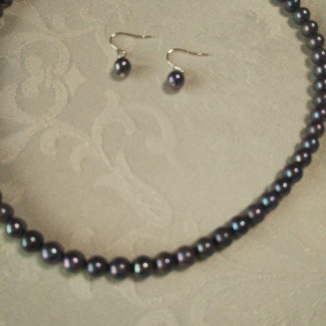 Akoya pearl necklace and matching earrings with silver clasp and findings on white background
