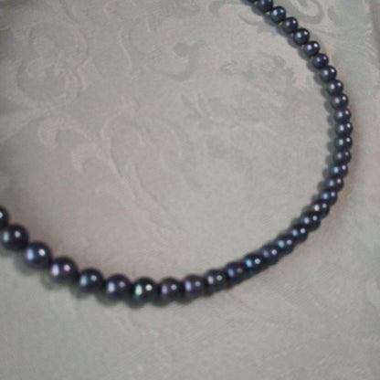 Akoya pearl necklace and matching earrings with silver clasp and findings on white background