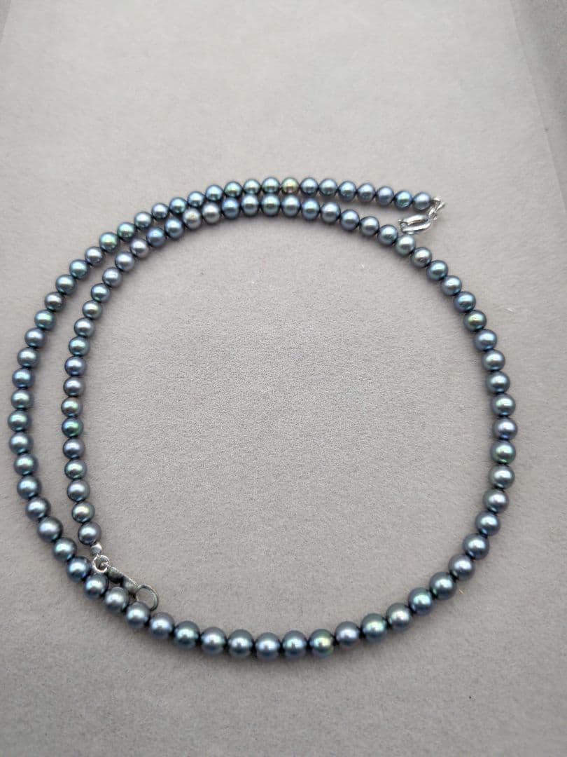 Akoya cultured pearl baby necklace with black peacock tone pearls and silver clasp on white background