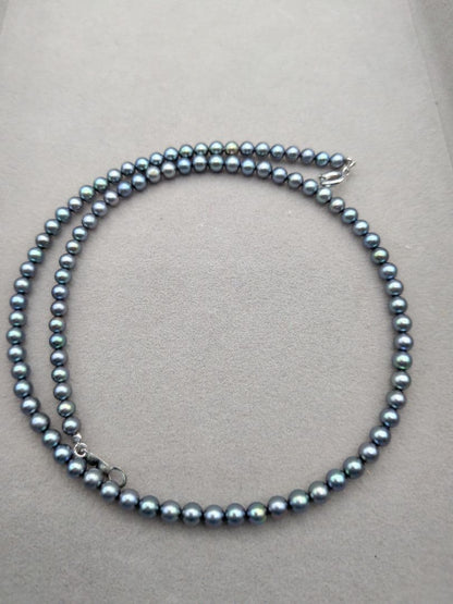 Akoya cultured pearl baby necklace with black peacock tone pearls and silver clasp on white background