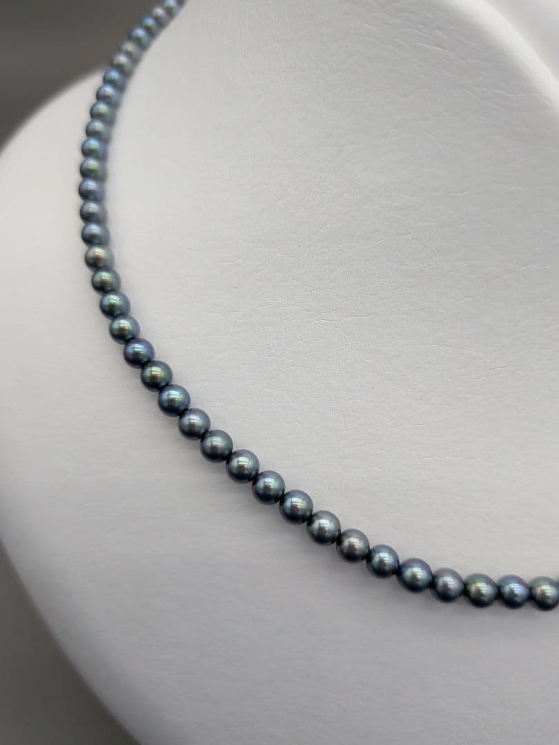 Akoya cultured pearl baby necklace with black peacock tone pearls and silver clasp on white background