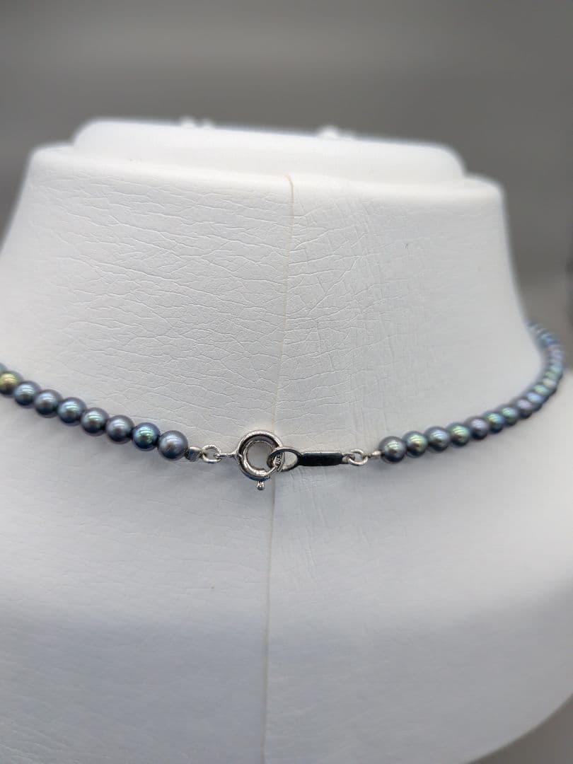 Akoya cultured pearl baby necklace with black peacock tone pearls and silver clasp on white background