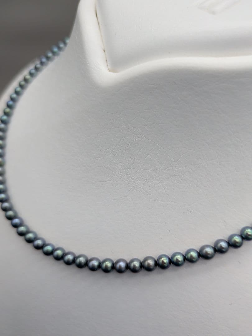 Akoya cultured pearl baby necklace with black peacock tone pearls and silver clasp on white background