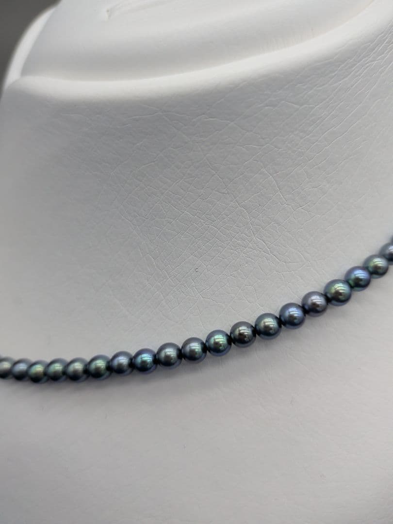 Akoya cultured pearl baby necklace with black peacock tone pearls and silver clasp on white background
