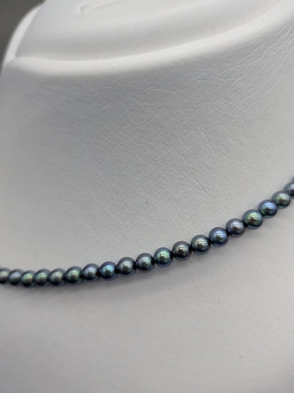 Akoya cultured pearl baby necklace with black peacock tone pearls and silver clasp on white background