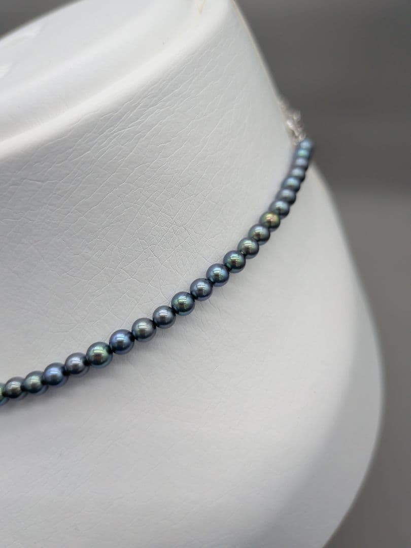Akoya cultured pearl baby necklace with black peacock tone pearls and silver clasp on white background