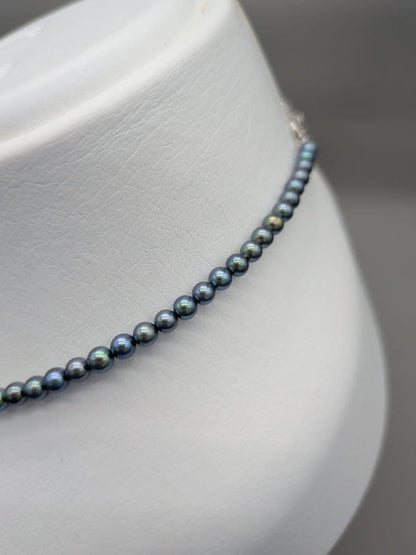 Akoya cultured pearl baby necklace with black peacock tone pearls and silver clasp on white background