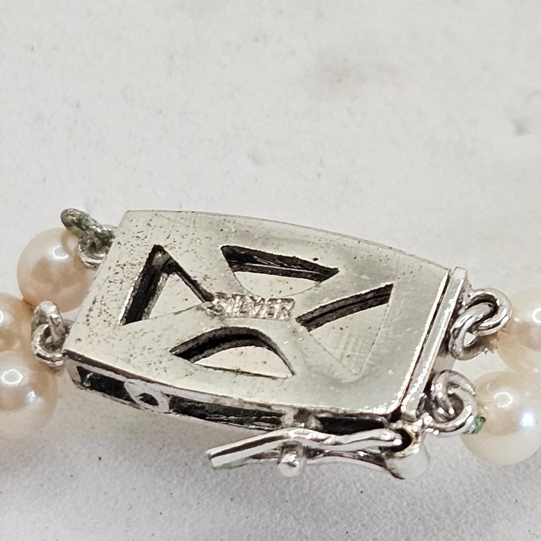 Akoya pearl two-strand gradient necklace with silver clasp, 43cm length displayed on white background