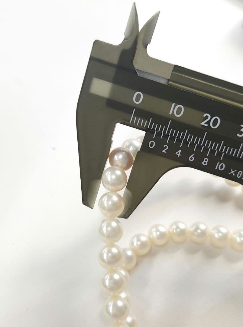 Akoya Pearl Necklace featuring 7 mm white pearl beads, 42 cm length, laid out on a white background