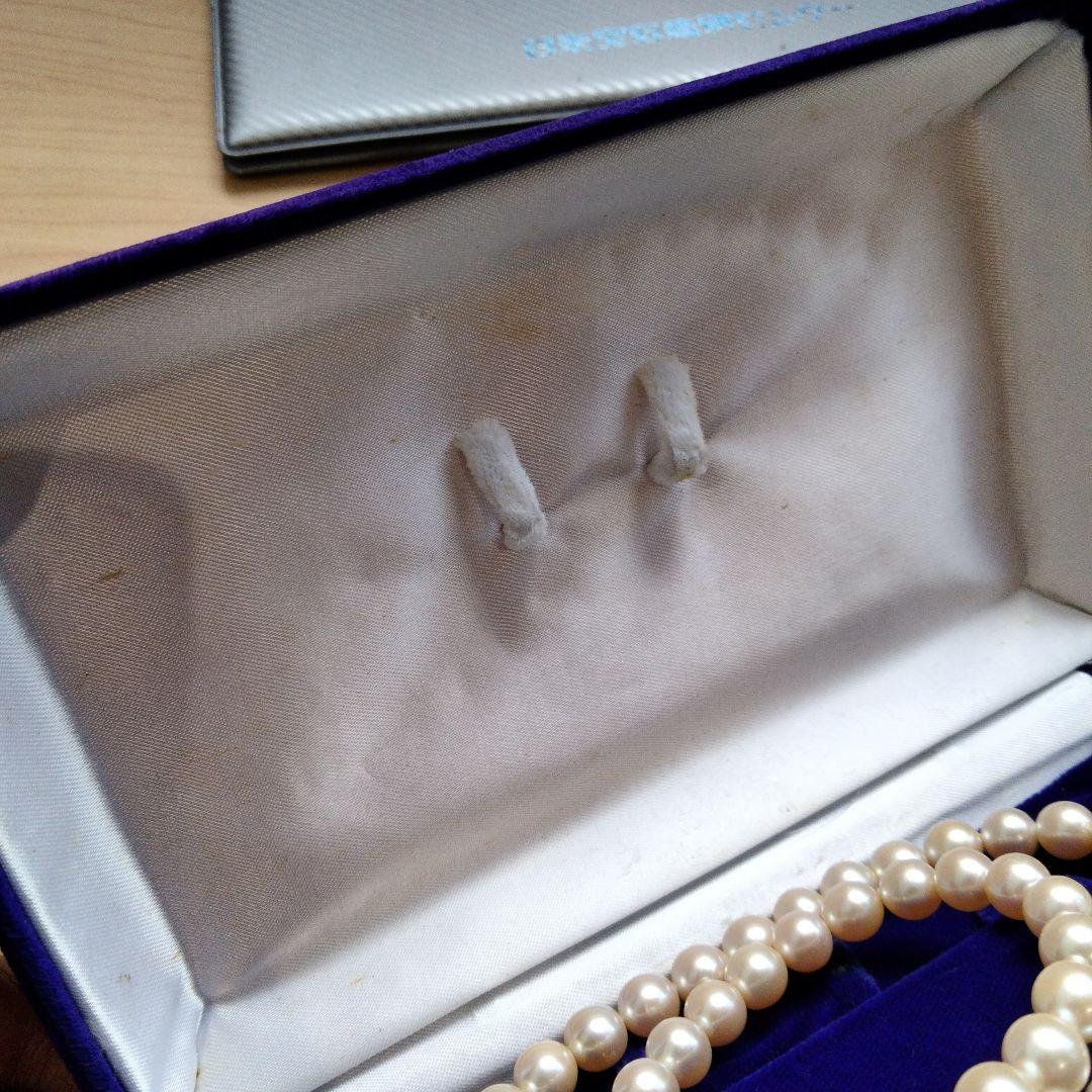 Akoya pearl necklace and matching earrings set with white pearls and silver clasp on a white background