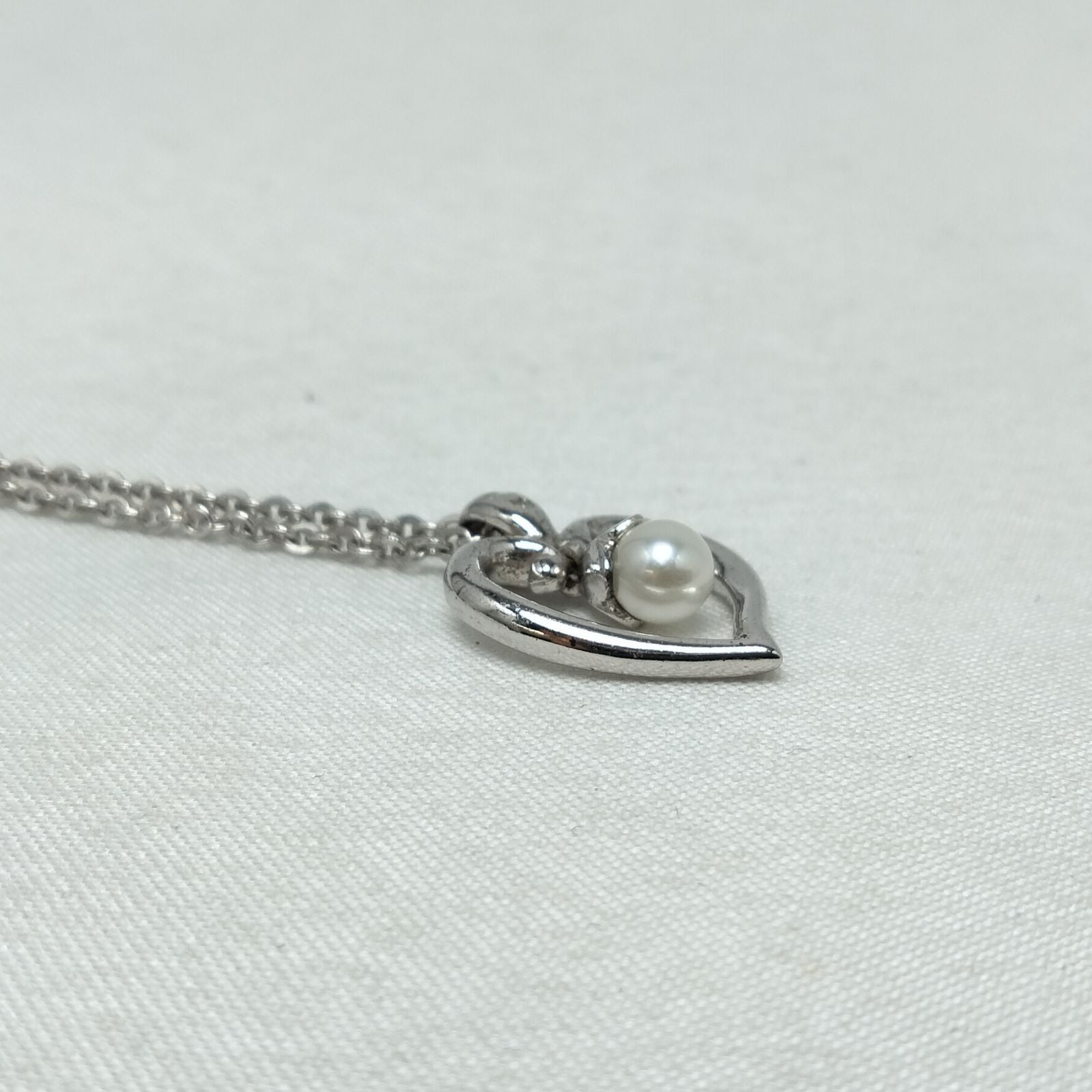 MIKIMOTO silver heart necklace with a 0.5cm pearl pendant and 19cm chain on white background