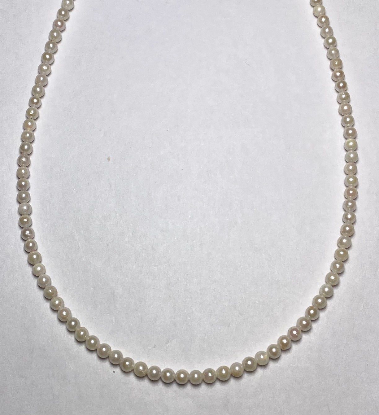 Akoya pearl baby pearl necklace with 3.0-3.5mm pearls and silver adjuster on white background