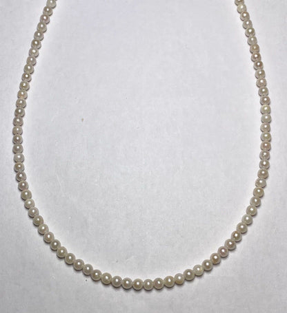 Akoya pearl baby pearl necklace with 3.0-3.5mm pearls and silver adjuster on white background
