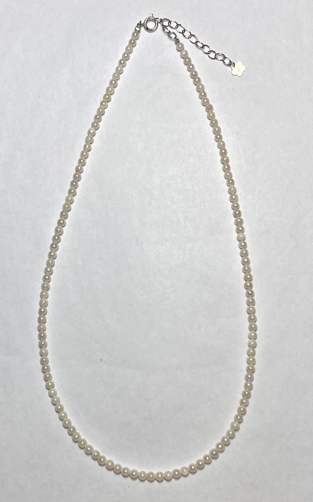 Akoya pearl baby pearl necklace with 3.0-3.5mm pearls and silver adjuster on white background