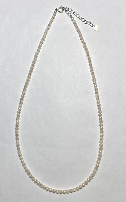 Akoya pearl baby pearl necklace with 3.0-3.5mm pearls and silver adjuster on white background