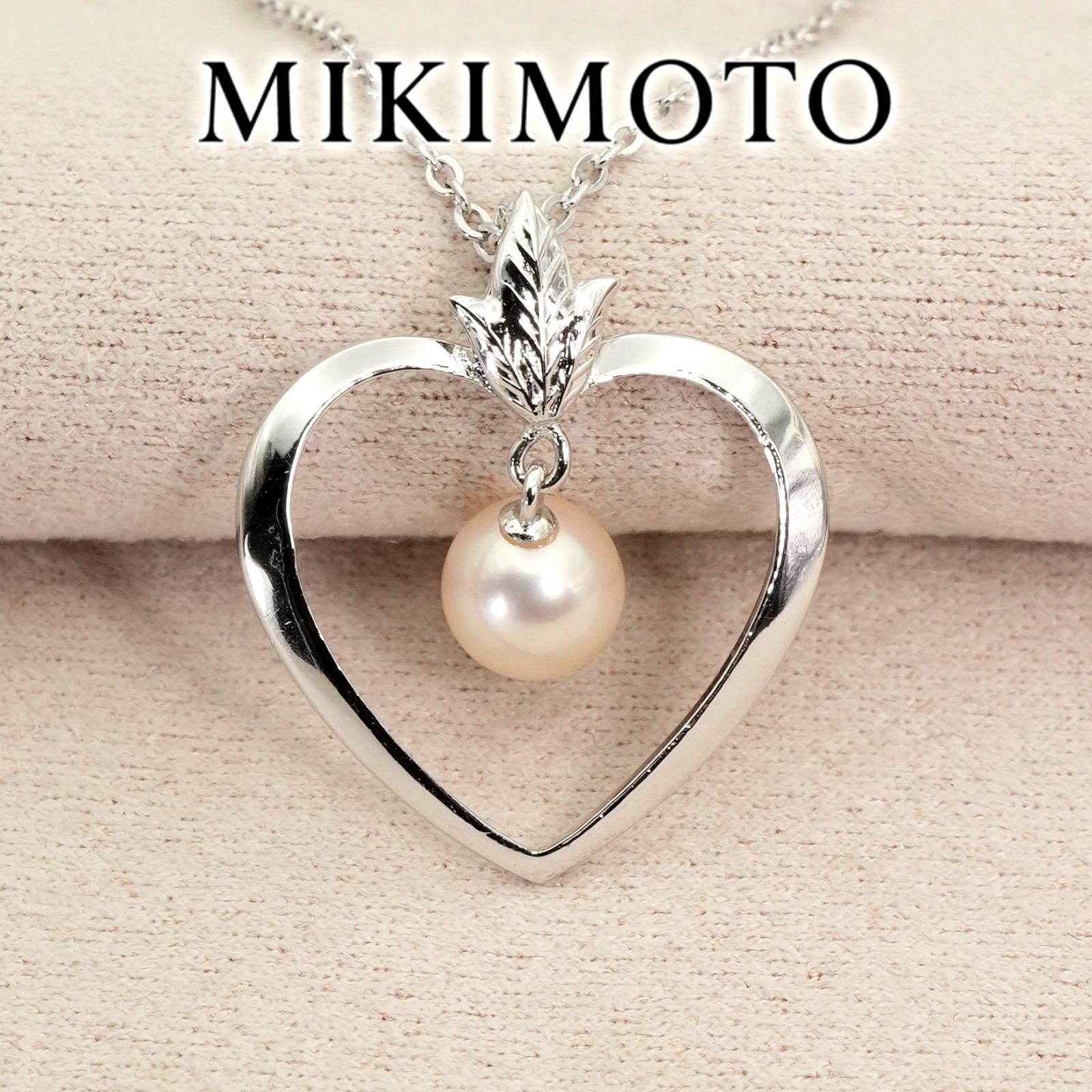 Mikimoto heart-shaped pearl necklace with silver chain displayed against white background