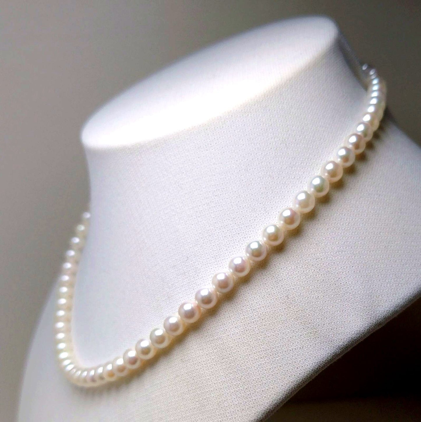 Akoya pearl necklace featuring round 5.5-6.0mm white, green, and pink pearls with good luster
