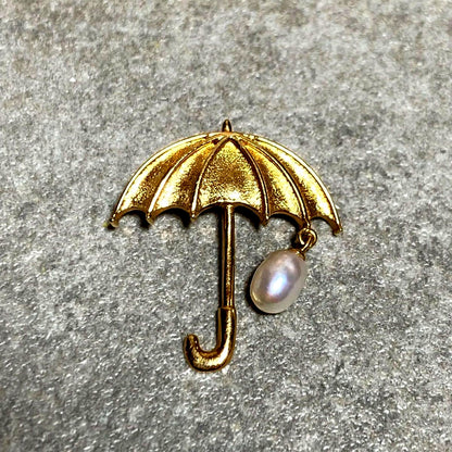 Tasaki necklace top with umbrella motif in K18 yellow gold featuring a pearl, shown in used condition with small scratches
