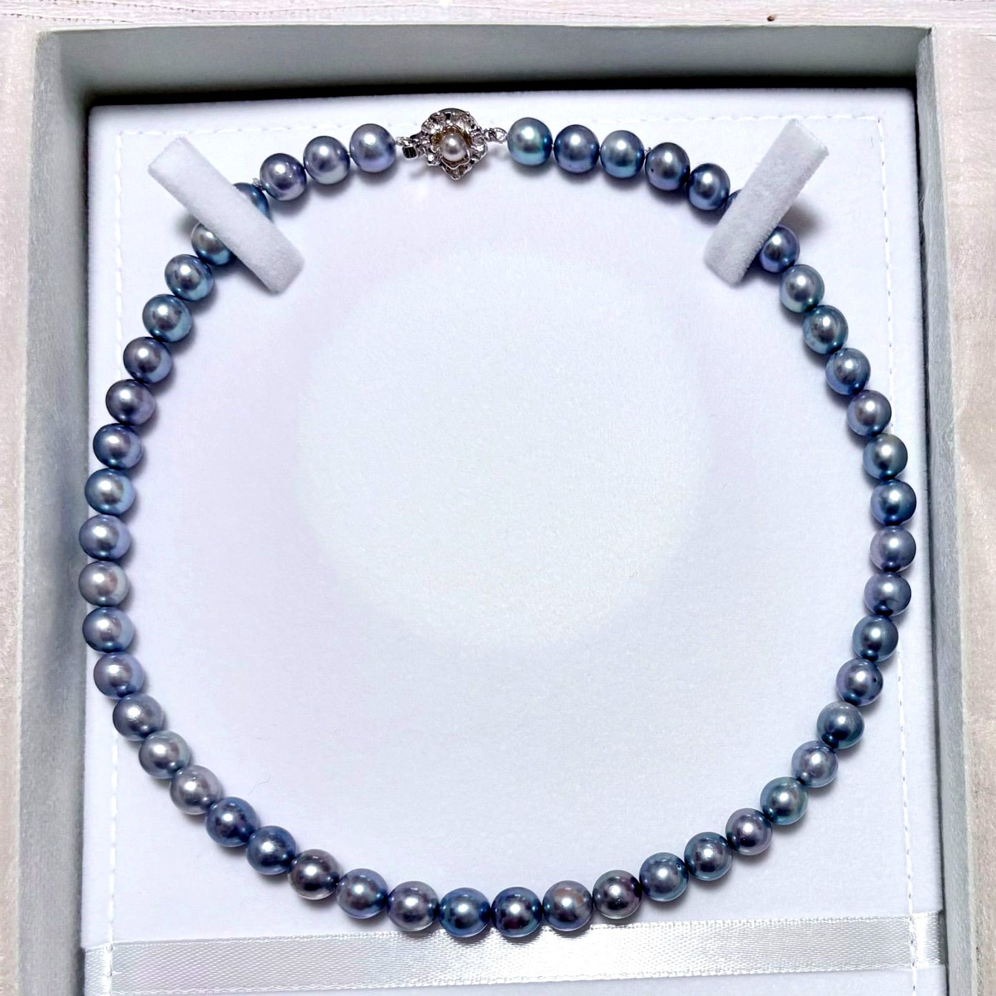 Honmei pearl necklace featuring 8mm blue gray pearls and silver engraved clasp on a white background