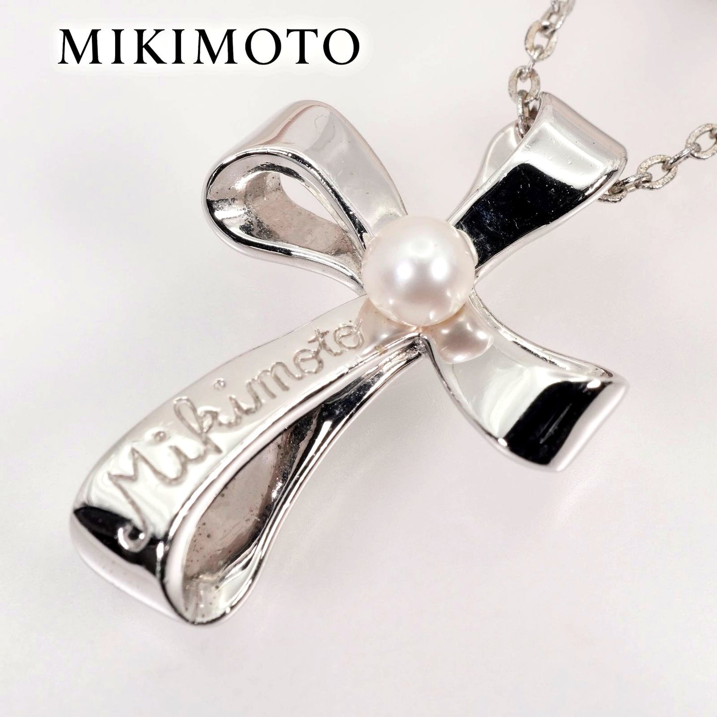 Mikimoto silver necklace with a baby pearl cross pendant, showcasing delicate craftsmanship and polished finish