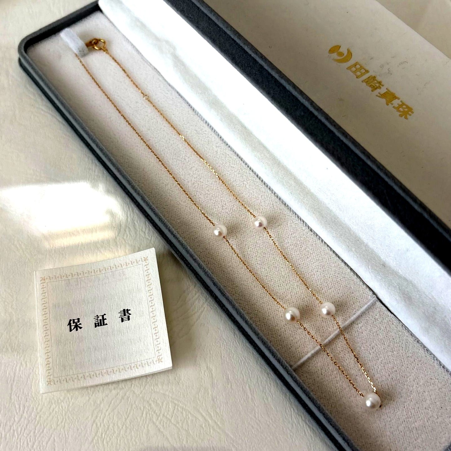 094TasakiK18 pearl 5-string station necklace displayed with box and warranty