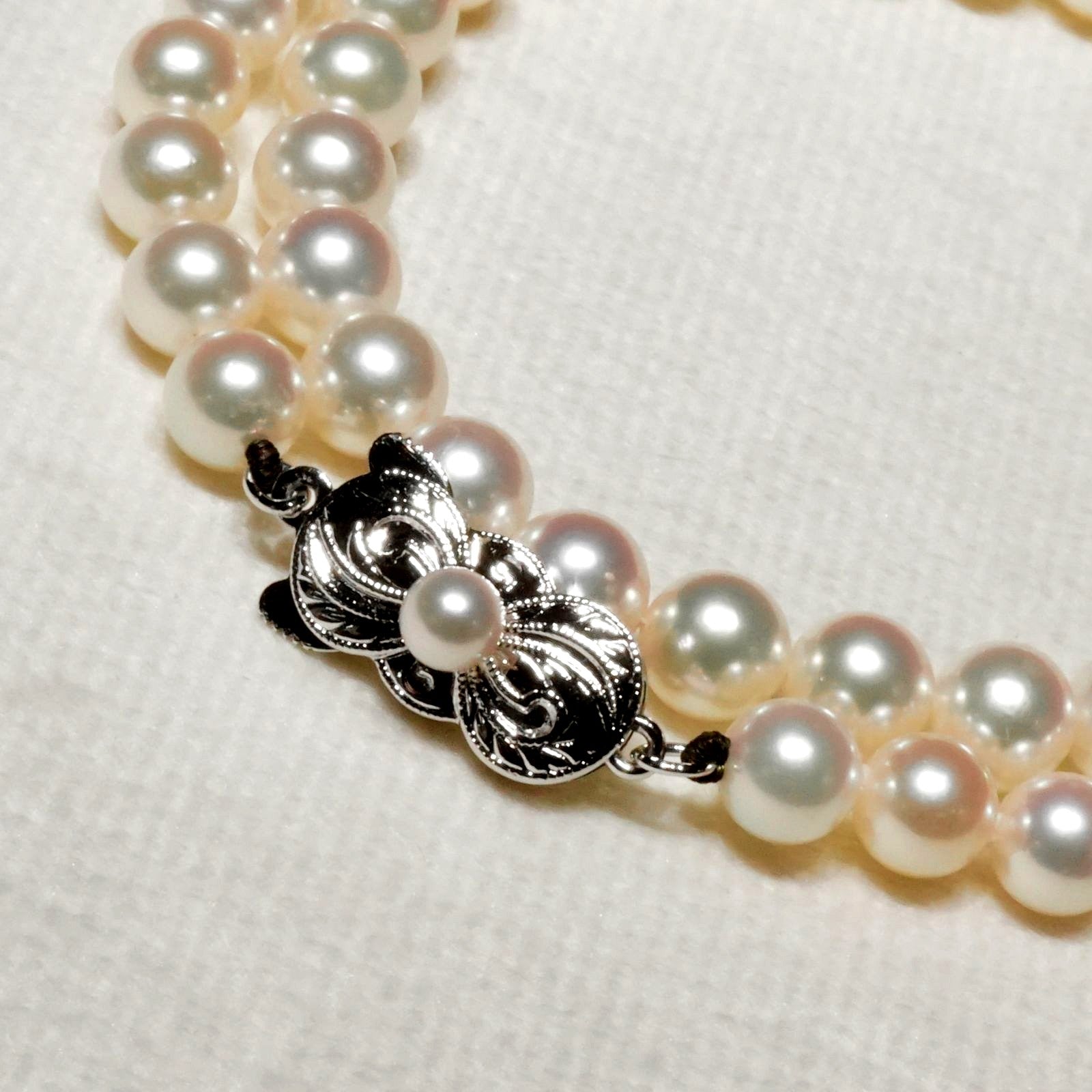 Mikimoto Akoya pearl necklace with 6.4mm pearls and silver current clasp on white background