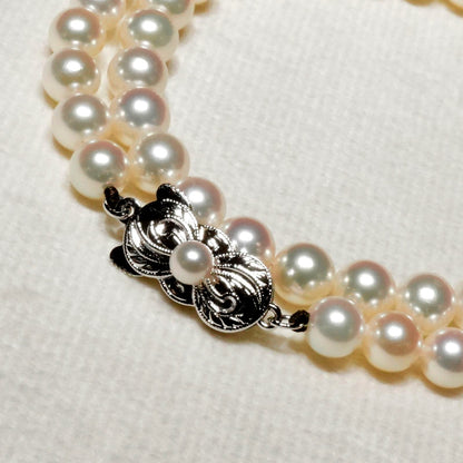 Mikimoto Akoya pearl necklace with 6.4mm pearls and silver current clasp on white background
