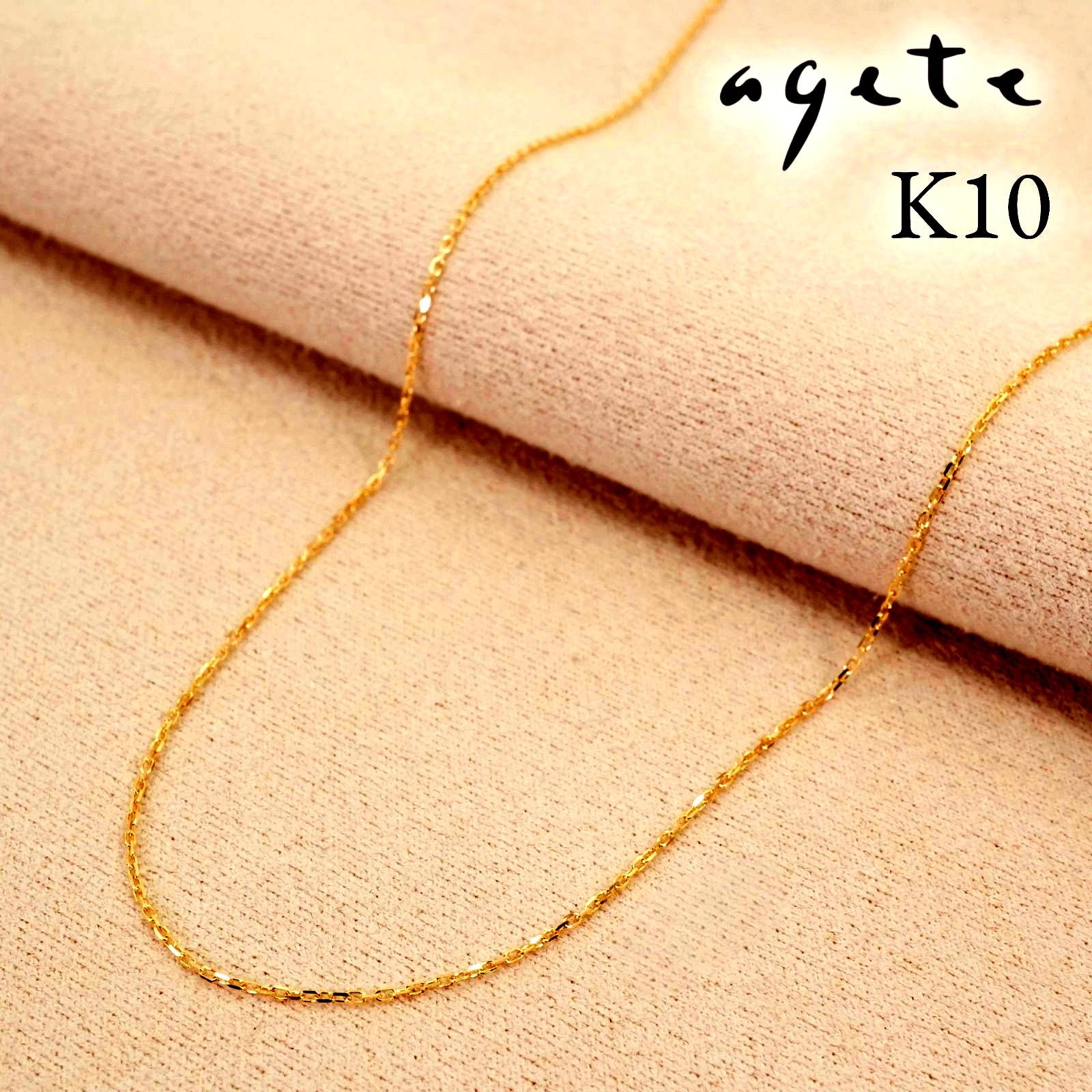 Agete K10 gold necklace chain laid out showing its fine links and polished finish