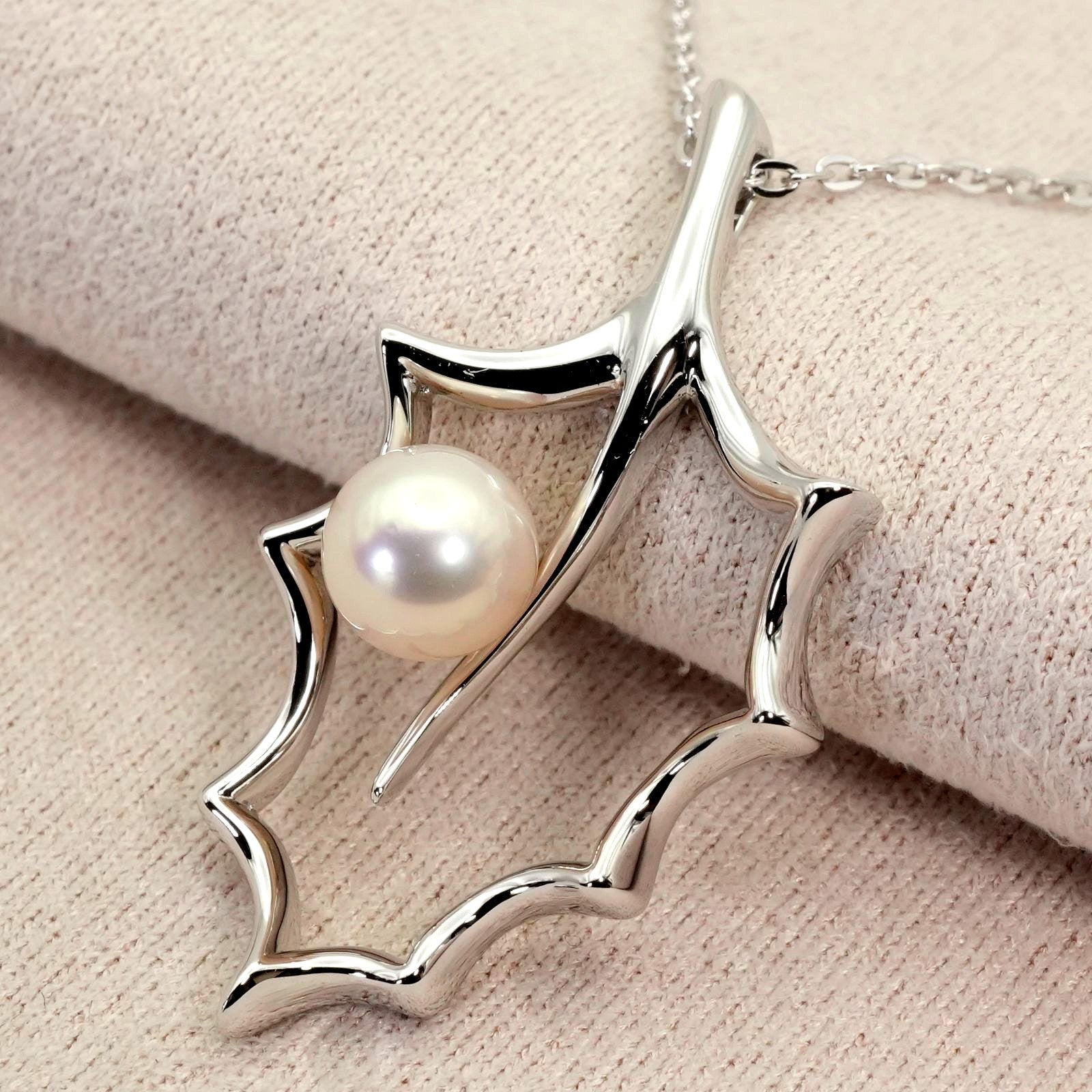Mikimoto Hollyhock necklace featuring a silver chain and a single pearl pendant with floral design