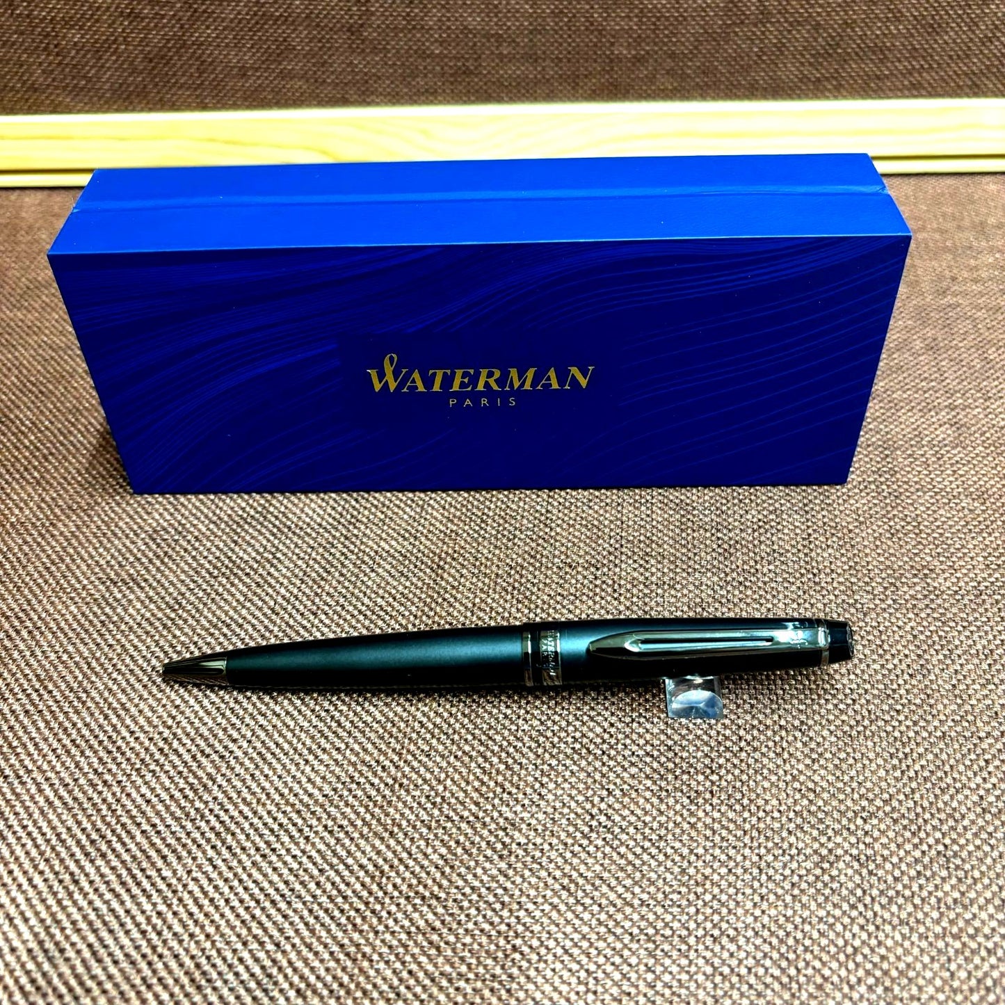 WATERMAN Expert Metallic Black ballpoint pen with brass body and twist mechanism shown from side angle