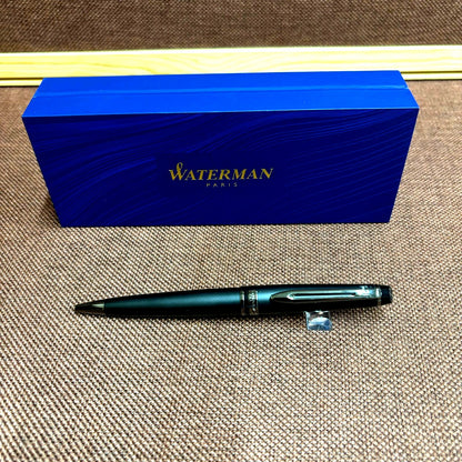 WATERMAN Expert Metallic Black ballpoint pen with brass body and twist mechanism shown from side angle