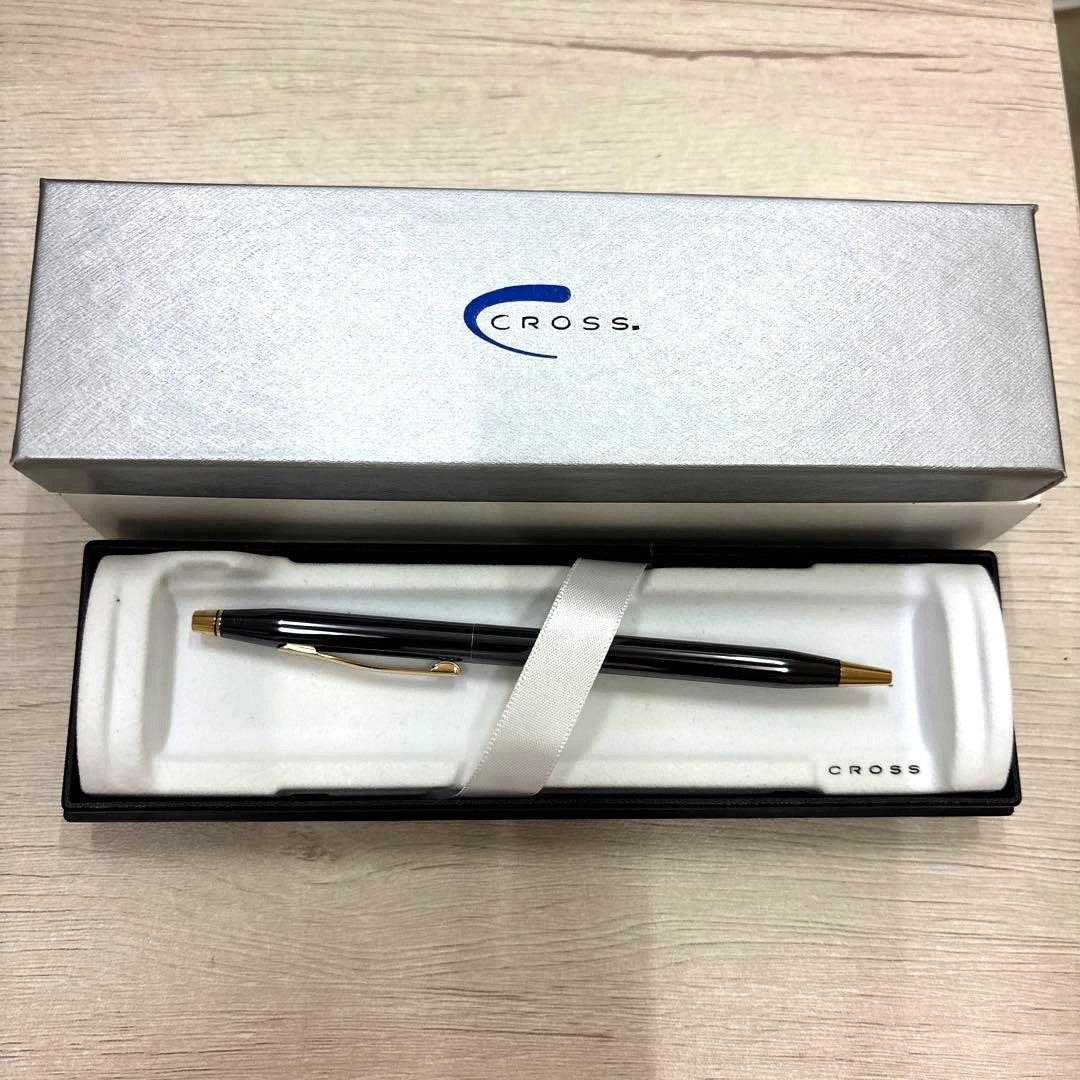 Cross black ballpoint pen with gold accents displayed alongside its dedicated black case