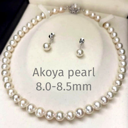 Large white Akoya pearl necklace and matching earrings with 8.5mm pearls and silver accents on white background