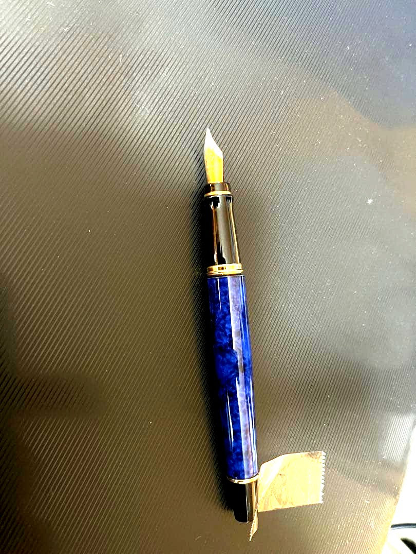 Waterman fountain pen with blue marble finish, gold trim, and medium gold nib on white background